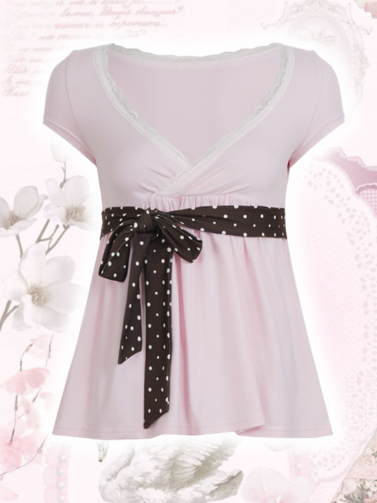 Pink top with a black polka dot ribbon on a floral background